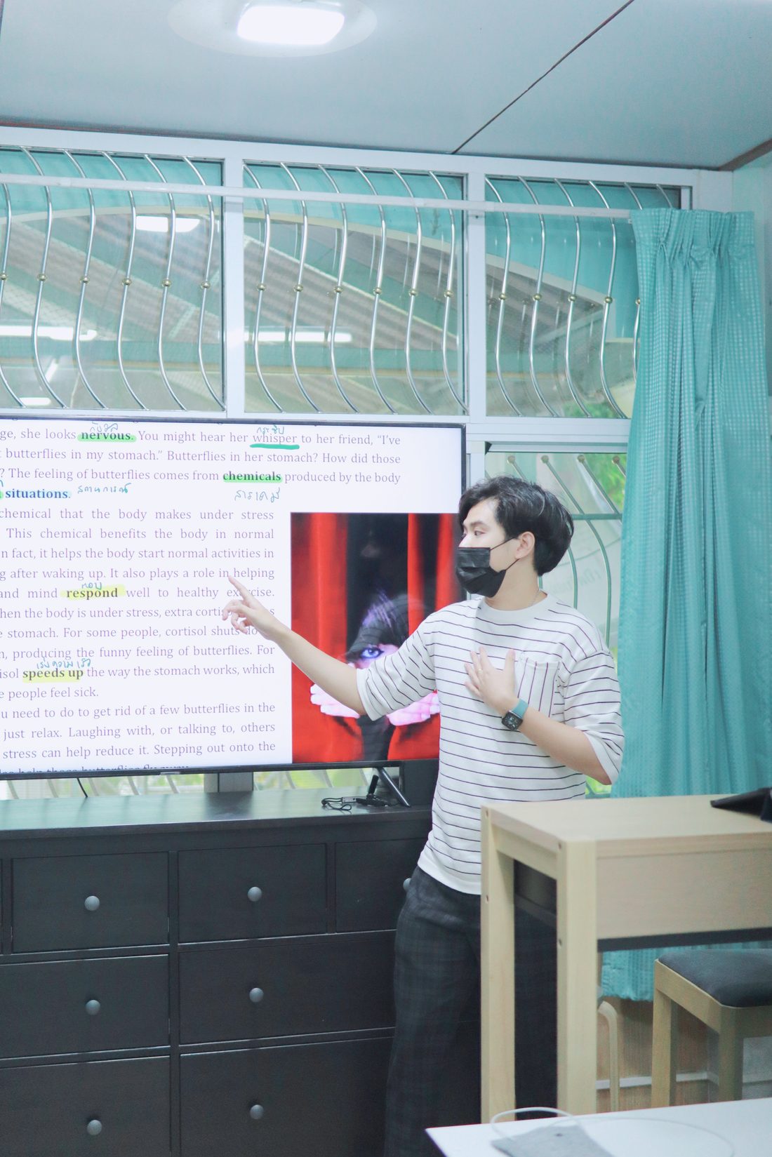 ครูชี้อธิบายคำศัพท์ในบทอ่านบนจอทีวี